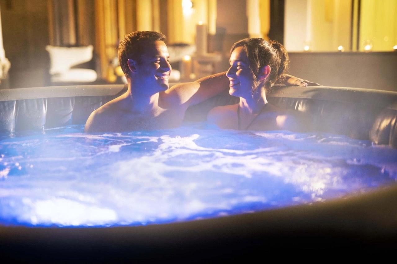 A couple relaxing in an illuminated hot tub — lifestyle photograph